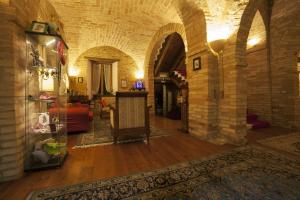 una sala de estar con una pared de piedra y una mesa. en La Luma Hotel en Montecosaro