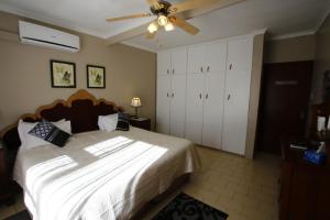 a bedroom with a bed and a ceiling fan at Bluewater Guesthouse in Port Elizabeth