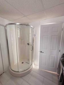 ducha en una habitación con puerta blanca en Au paradis de l'Ashuap en Saint-Félicien