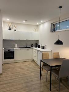 a kitchen with white cabinets and a table with chairs at Moderne Wohnung in Heskem bei Marburg (Lahn) 