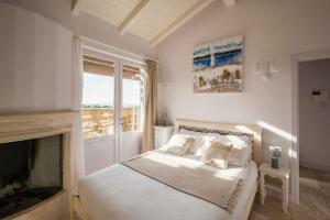 ein weißes Schlafzimmer mit einem Bett und einem Kamin in der Unterkunft Castel del Mare in San Vincenzo