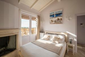 Dormitorio blanco con cama y chimenea en Castel del Mare, en San Vincenzo