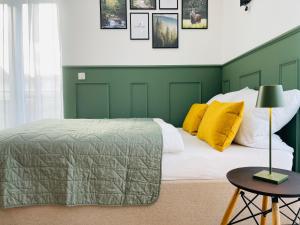 Habitación verde y blanca con cama y mesa en Stay zentrale Schwarzwald Apartments, en Nagold