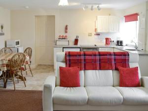 un soggiorno con divano bianco e una cucina di Foxglove Cottage a Wootton Fitzpaine