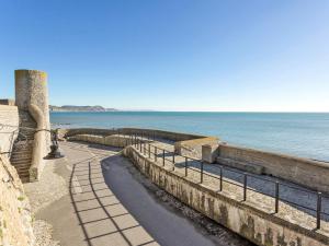 a walkway next to the ocean next to a wall at Foxglove Cottage in Wootton Fitzpaine