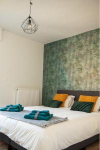 Una gran cama blanca con toallas azules. en Vakantiewoning Dorp-28, en Hollebeke