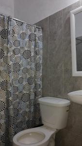 a bathroom with a toilet and a shower curtain at Casas y departamentos in Oxkutzcab