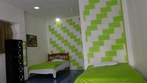 um quarto com quadrados verdes e brancos nas paredes em Casas y departamentos em Oxkutzcab