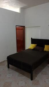 a black bed in a room with a wall at Casas y departamentos in Oxkutzcab