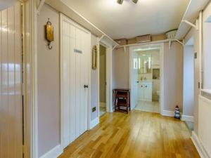 a living room with a hallway with a hard wood floor at Yellow Welsh Cottage-Coastal Retreat Village View in Bridgend
