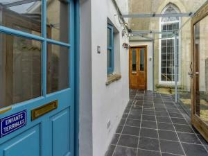 a blue door on a building with a walkway at Yellow Welsh Cottage-Coastal Retreat Village View in Bridgend