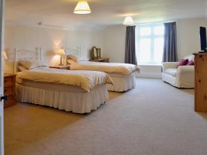 una camera d'albergo con due letti e un divano di Court Place a Porlock
