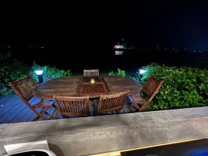 Appartement vu Mer & Piscine في لو جوسيير: طاولة وكراسي خشبية على سطح السفينة في الليل