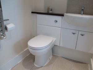 Baño blanco con aseo y lavamanos en Apartment 11 - Latitude 51, en Westward Ho
