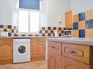 a kitchen with a washing machine and a window at Court Place in Porlock