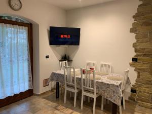 a dining room with a table and chairs and a tv at Galleno house in Galleno