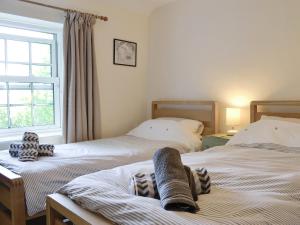 a bedroom with two beds and a window at Ty Newydd Y Graig - 28017 in Tremeirchion