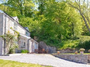 an exterior view of a stone house with a gravel driveway at Ty Newydd Y Graig - 28017 in Tremeirchion