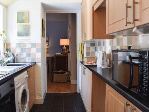 a kitchen with a washer and dryer on the counter at Helens Lea in St. Andrews
