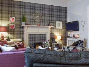 a living room with a couch and a fireplace at Helens Lea in St. Andrews