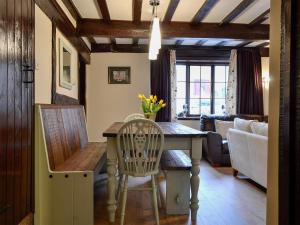 cocina y sala de estar con mesa y sillas en The Old Farmhouse, en Blakeney