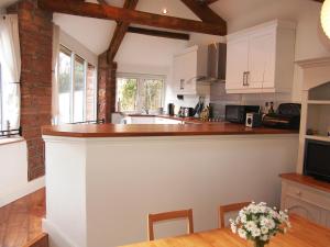a kitchen with white cabinets and a counter top at Woodstore Cottage in Lazonby
