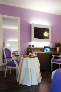 une salle à manger avec des murs violets, une table et des chaises dans l'établissement Bed&Garden, à Cesate