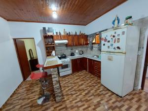 cocina con nevera blanca y suelo de madera en Naturaleza pura en Puerto Iguazú