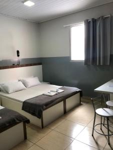 um quarto com uma cama, uma mesa e uma janela em Hotel sany - Localizado à 5 minutos do Metrô Paulista em São Paulo