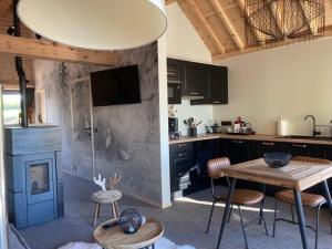 a kitchen with a table and chairs and a fireplace at Les pavillons de La Libellule in Beauraing