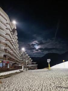 een gebouw op een met sneeuw bedekt strand 's nachts bij Appartement la Plagne,7 pers rénové in Aime La Plagne