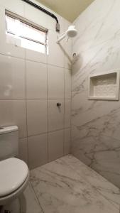 a bathroom with a toilet and a marble wall at Diamantina Palace Hotel in Morro do Chapéu