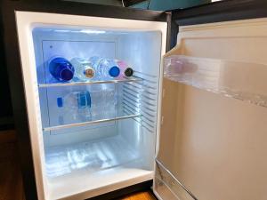 an open refrigerator with bottles of water in it at Peaceful and Central Room with Balcony next to Hilton in Athens