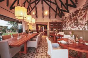 a dining room with a long wooden table and chairs at Otjiwa Safari Lodge in Otjiwarongo