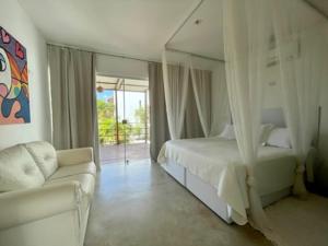 琵琶的住宿－La Réserve Design Villas，一间卧室配有一张床、一张沙发和一面镜子
