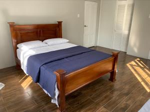 a bedroom with a bed with a blue blanket and white pillows at Trincity Apartment in Trincity  +5 photos