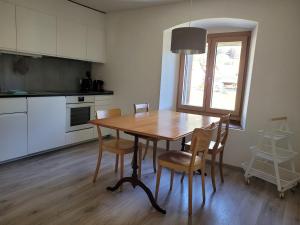 cocina con mesa de madera y sillas en Ferienwohnung PARDI, en Lenz