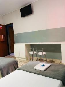 a hotel room with two chairs and a tv on the wall at Hotel sany - Localizado à 5 minutos do Metrô Paulista in São Paulo