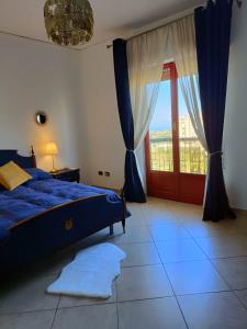 um quarto com uma cama azul e uma janela em B&B Margherita em Bagheria