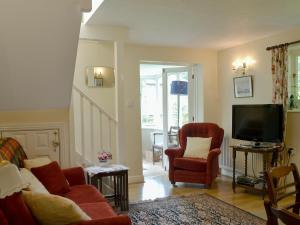 een woonkamer met 2 stoelen en een televisie bij The Coach House in Southampton