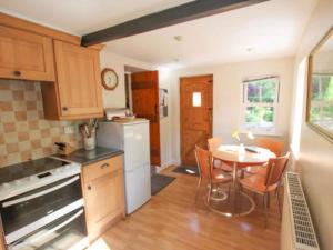 uma pequena cozinha com uma mesa e uma mesa e cadeiras em Cam Beck Cottage em Kettlewell