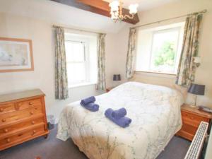 um quarto com uma cama com toalhas azuis em Cam Beck Cottage em Kettlewell