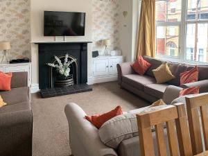 a living room with a couch and a fireplace at Upper Floors At The Lawns in Filey