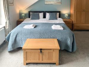 - une chambre avec un grand lit et une table en bois dans l'établissement Upper Floors At The Lawns, à Filey