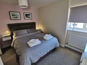 a bedroom with a bed with two towels on it at Griffin Apartments in Nottage