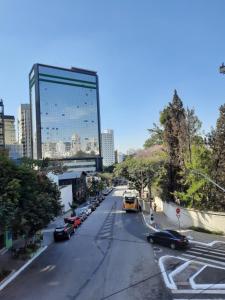 a city street with cars and a tall building at Hotel Sany SP- Metrô Paulista in São Paulo