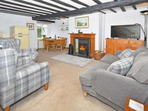 a living room with two couches and a fireplace at Osprey Cottage in Bassenthwaite