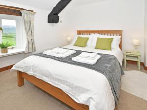 a bedroom with a bed with two towels on it at Osprey Cottage in Bassenthwaite