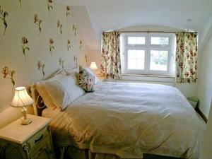 a bedroom with a large bed and a window at Starboard Cottage in Winterton-on-Sea
