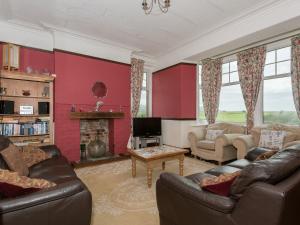 a living room with two couches and a fireplace at Hartrees House in Silecroft